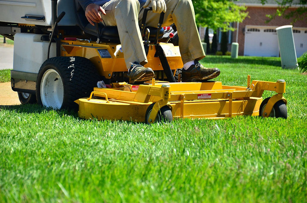 man driving a lawn mowing machine